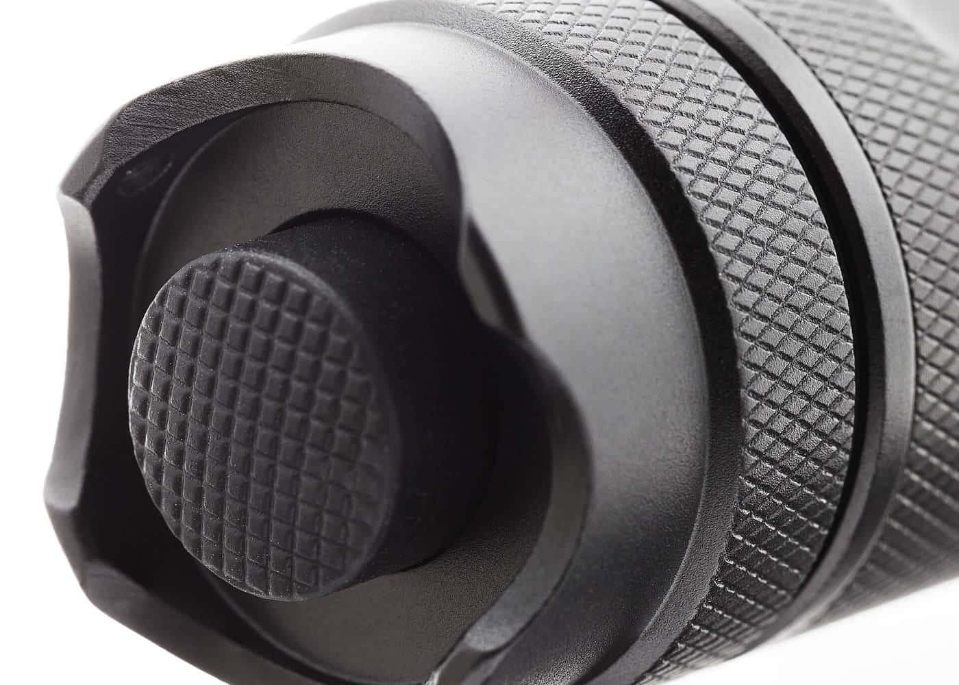 Close-up of the tail cap switch of an LED torch